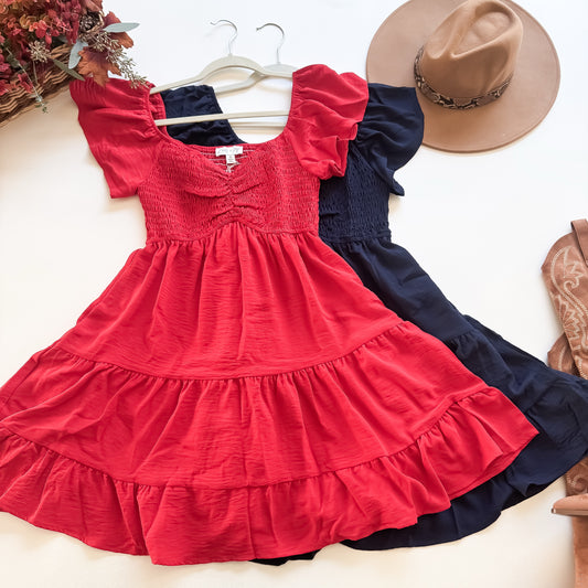 Red and navy smocked tiered mini dresses flat lay